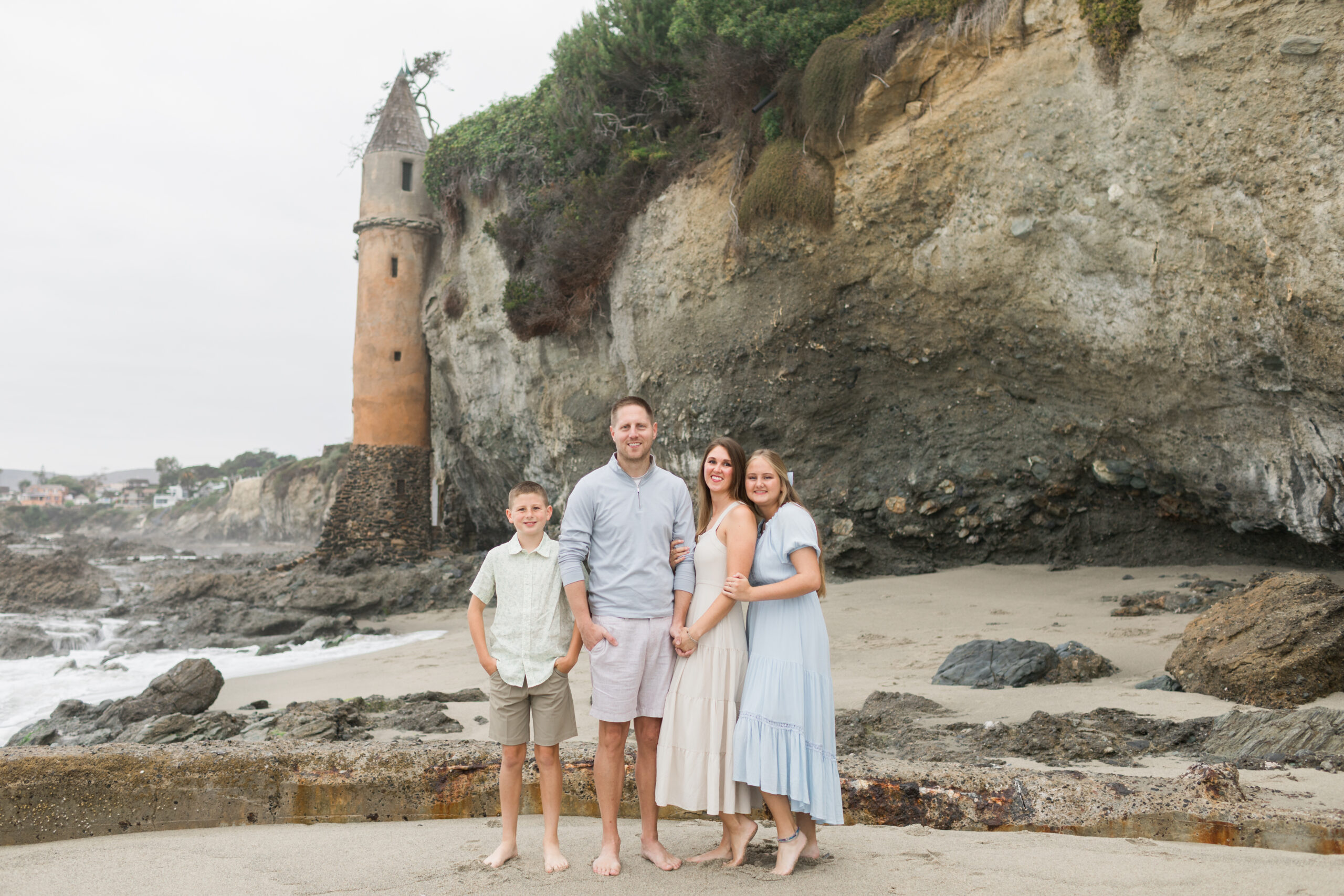 A family posing for a family portrait on Victoria Beach in Laguna Beach, CA, Orange County.
